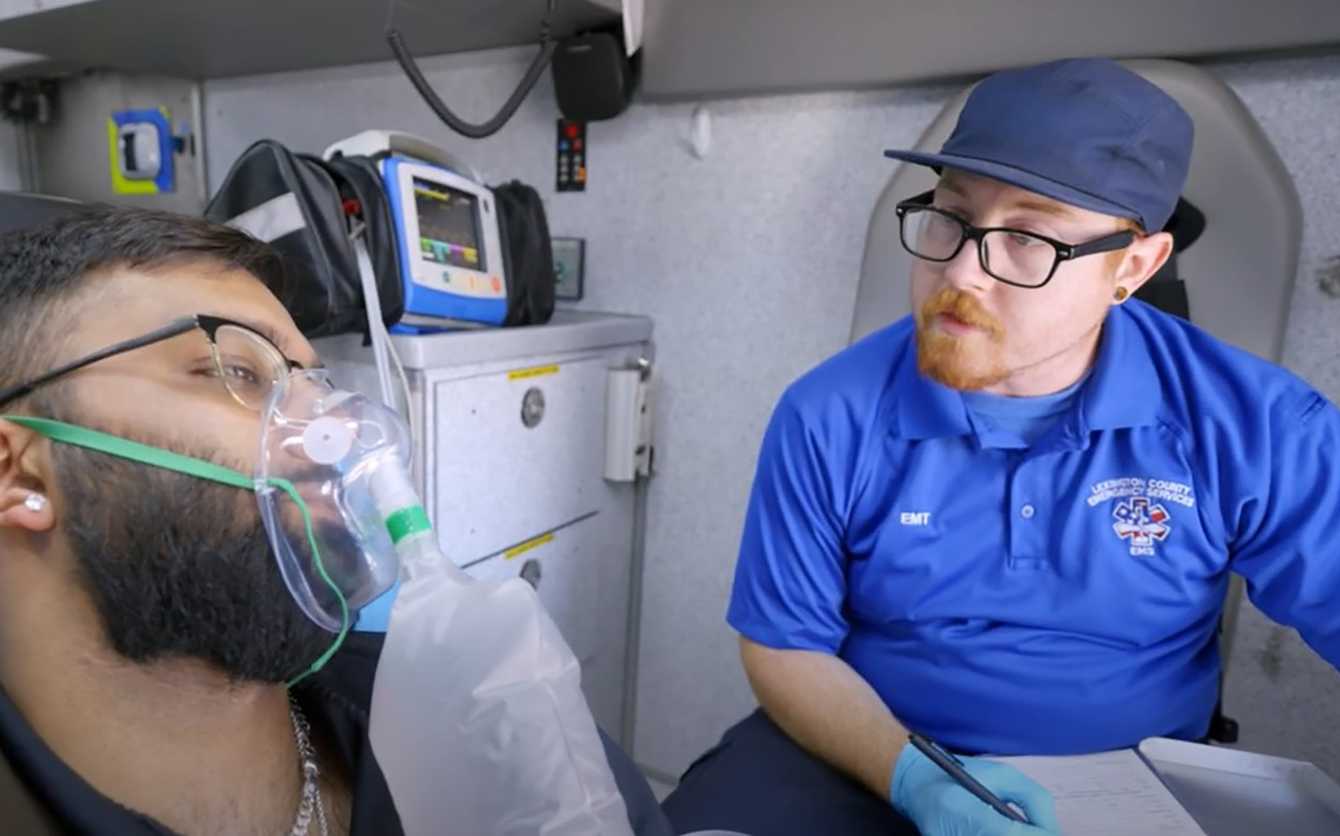 Peter Wylie inside an EMS vehicle with a person wearing a breathing apparatus